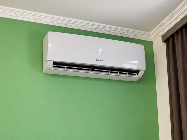 Ar-condicionado split Consul instalado em parede verde, com sanca decorativa